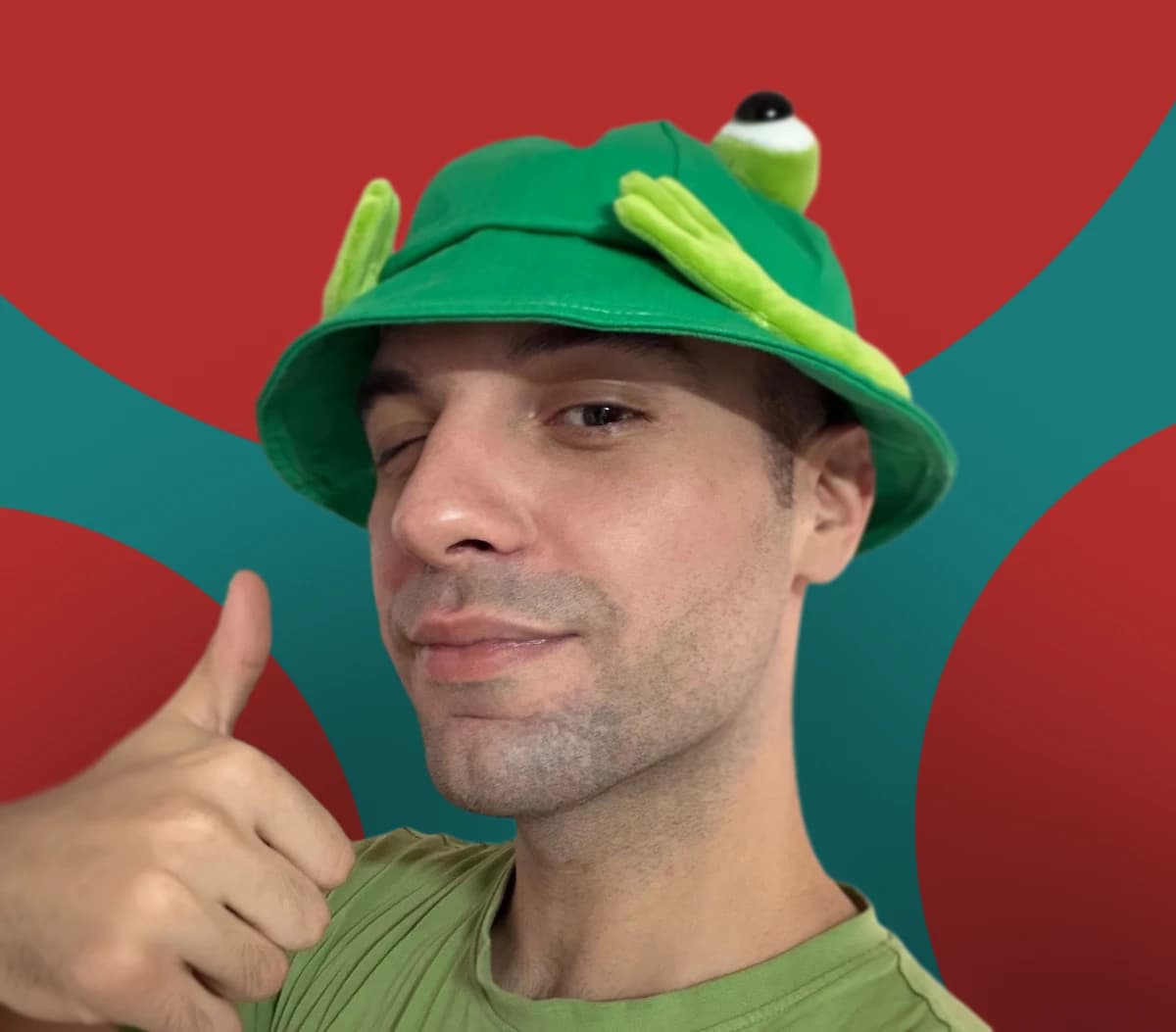 Filip Lazarov wearing a green frog hat and giving a thumbs-up